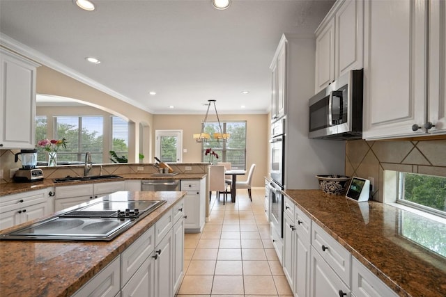 25 Falling Oaks Trl, The Hills, TX 78738 - kitchen with appliances with stainless steel finishes, decorative backsplash, white cabinetry, recessed lighting, and crown molding