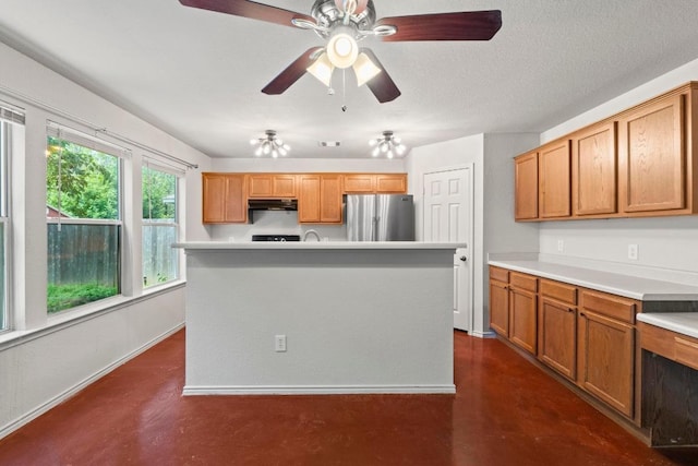 4608 Acers Ln, Austin, TX 78725 - kitchen with freestanding refrigerator, under cabinet range hood, light countertops, and finished concrete floors