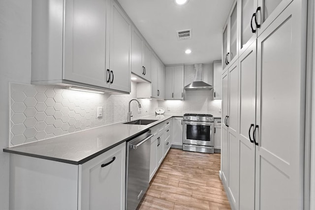 9710 Curlew Dr, Austin, TX 78748 - kitchen featuring stainless steel appliances, wall chimney exhaust hood, light wood-style flooring, recessed lighting, and tasteful backsplash
