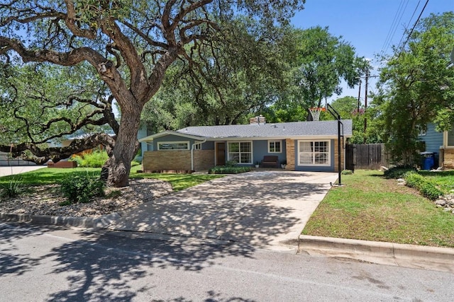 4604 Rue St, Austin, TX 78731 - ranch-style home with concrete driveway, brick siding, and a chimney