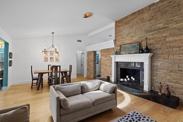 4604 Rue St, Austin, TX 78731 - living area featuring a chandelier, light wood-style floors, a fireplace, and lofted ceiling