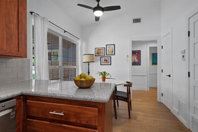 4604 Rue St, Austin, TX 78731 - kitchen featuring a peninsula, light wood-style flooring, a ceiling fan, backsplash, and brown cabinetry