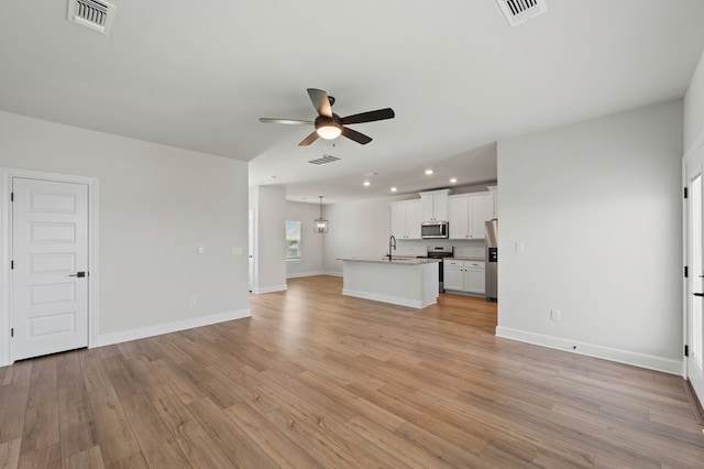 9517 Balmy Ln, Manor, TX 78653 - unfurnished living room featuring ceiling fan, recessed lighting, and light wood-style flooring