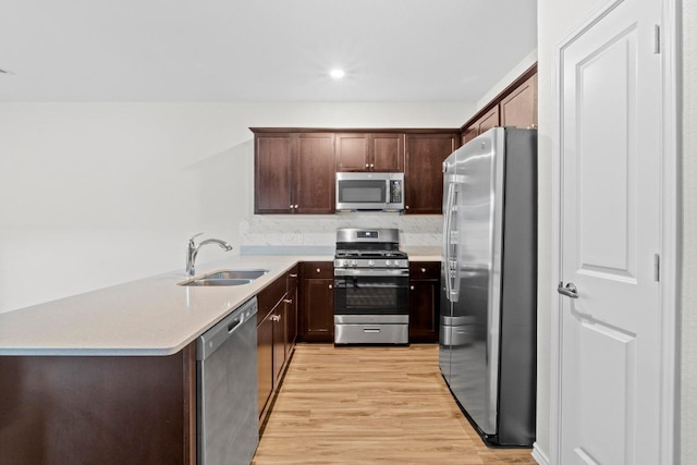 2416 Nightview Dr, Pflugerville, TX 78660 - kitchen with appliances with stainless steel finishes, light wood finished floors, light countertops, dark brown cabinets, and recessed lighting