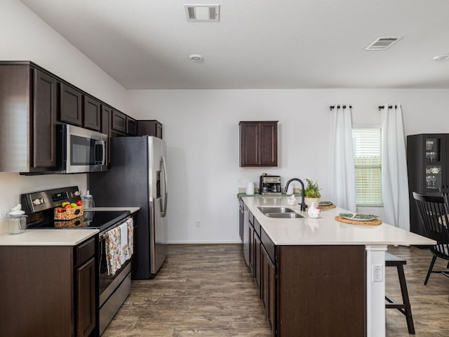 752 Circle Way Unit 35H, Jarrell, TX 76537 - kitchen featuring stainless steel appliances, a kitchen breakfast bar, dark brown cabinetry, and dark wood-style flooring