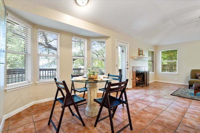 1601 Muledeer Run, Leander, TX 78641 - dining space with healthy amount of natural light, light tile patterned floors, a fireplace, and vaulted ceiling