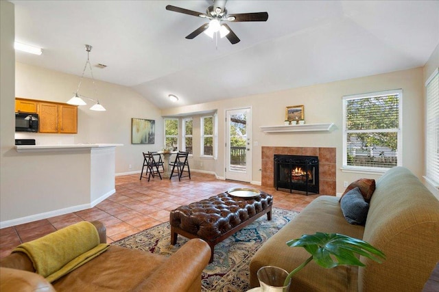 1601 Muledeer Run, Leander, TX 78641 - living room with light tile patterned floors, lofted ceiling, plenty of natural light, ceiling fan, and a tile fireplace