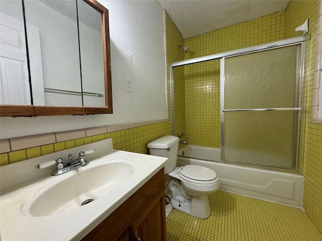 161 Fm 1209, Cedar Creek, TX 78612 - bathroom featuring combined bath / shower with glass door, vanity, a textured ceiling, tile walls, and a wainscoted wall