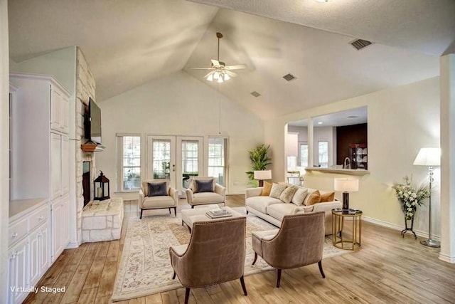 128 Moku Manu Dr, Bastrop, TX 78602 - living area with a ceiling fan, light wood finished floors, high vaulted ceiling, and a stone fireplace