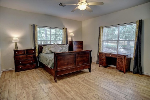 128 Moku Manu Dr, Bastrop, TX 78602 - bedroom featuring multiple windows, light wood-style floors, and a ceiling fan