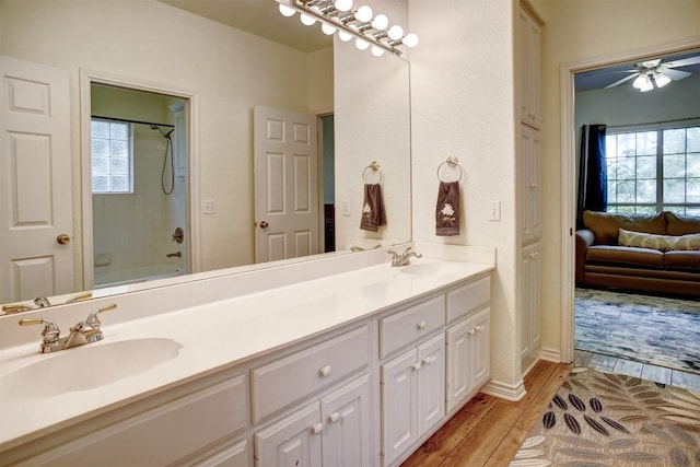 128 Moku Manu Dr, Bastrop, TX 78602 - ensuite bathroom with double vanity, shower / tub combination, wood finished floors, and a ceiling fan