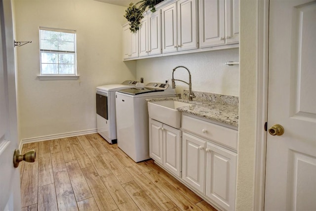 128 Moku Manu Dr, Bastrop, TX 78602 - laundry room with cabinet space, washing machine and dryer, and light wood finished floors