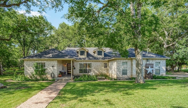 128 Moku Manu Dr, Bastrop, TX 78602 - cape cod-style house with stone siding and a front lawn