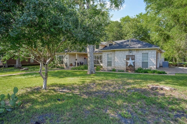 128 Moku Manu Dr, Bastrop, TX 78602 - ranch-style house with stone siding and a front yard