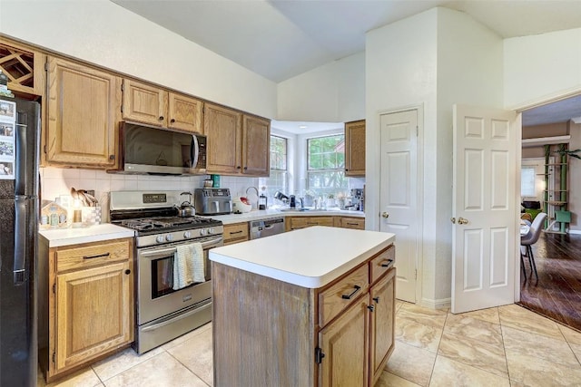 5907 Shanghai Pierce Rd, Austin, TX 78749 - kitchen featuring stainless steel appliances, light countertops, tasteful backsplash, a center island, and lofted ceiling
