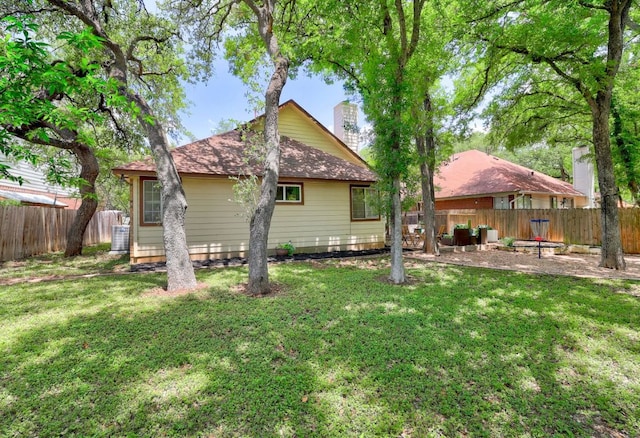 5907 Shanghai Pierce Rd, Austin, TX 78749 - back of property featuring a fenced backyard, a chimney, and a shingled roof