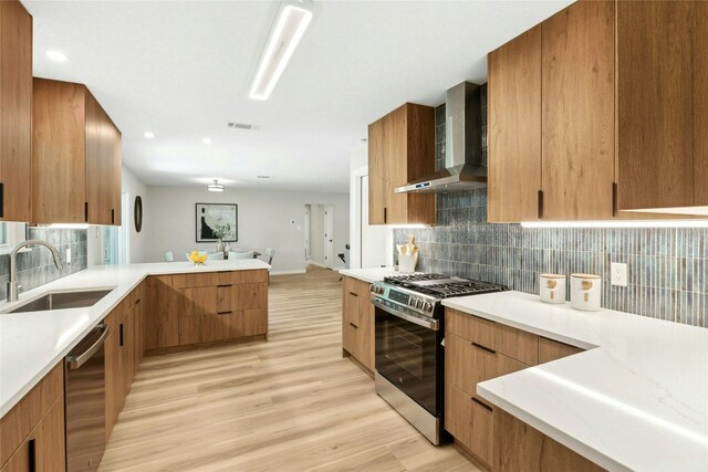 1806 Teton Dr, Austin, TX 78757 - kitchen featuring stainless steel appliances, wall chimney exhaust hood, light wood finished floors, light countertops, and decorative backsplash
