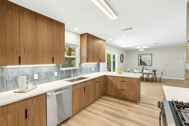 1806 Teton Dr, Austin, TX 78757 - kitchen featuring appliances with stainless steel finishes, a peninsula, light countertops, decorative backsplash, and recessed lighting