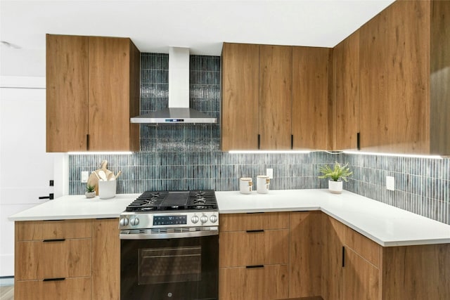 1806 Teton Dr, Austin, TX 78757 - kitchen featuring stainless steel gas range oven, wall chimney exhaust hood, modern cabinets, decorative backsplash, and light countertops