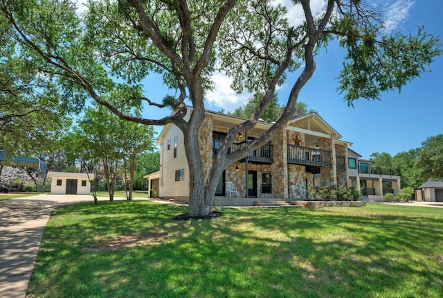 13109, 13111 Mansfield Dr Dr, Austin, TX 78732 - view of front of house with a balcony, stone siding, a front lawn, and an outbuilding