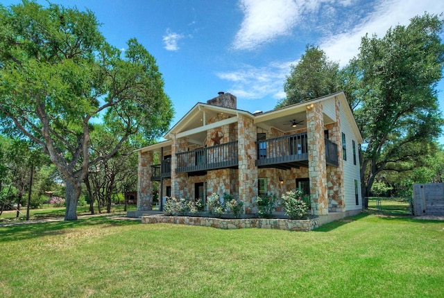 13109, 13111 Mansfield Dr Dr, Austin, TX 78732 - back of house featuring ceiling fan, a balcony, stone siding, and a chimney