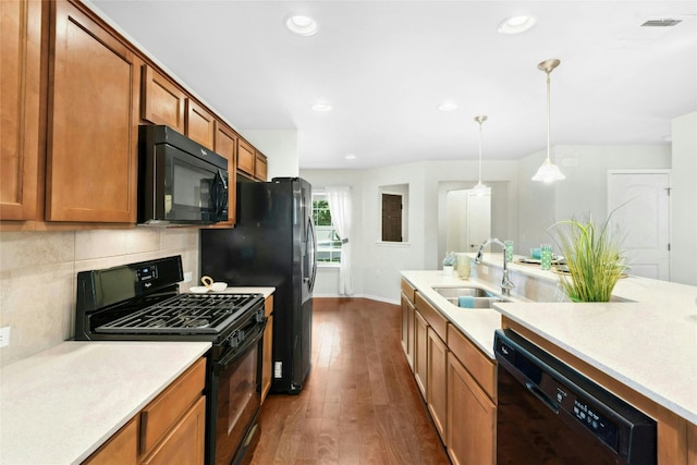 225 Hobby St, Georgetown, TX 78633 - kitchen with black appliances, dark wood finished floors, brown cabinetry, light countertops, and recessed lighting