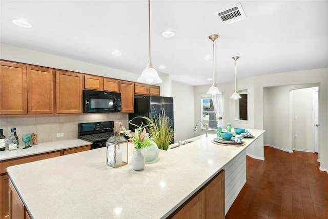 225 Hobby St, Georgetown, TX 78633 - kitchen featuring black appliances, brown cabinets, backsplash, a center island with sink, and recessed lighting