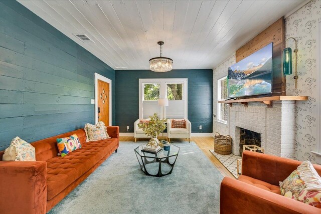 510 E 38th St, Austin, TX 78705 - living area with wood finished floors, a chandelier, wallpapered walls, and a brick fireplace