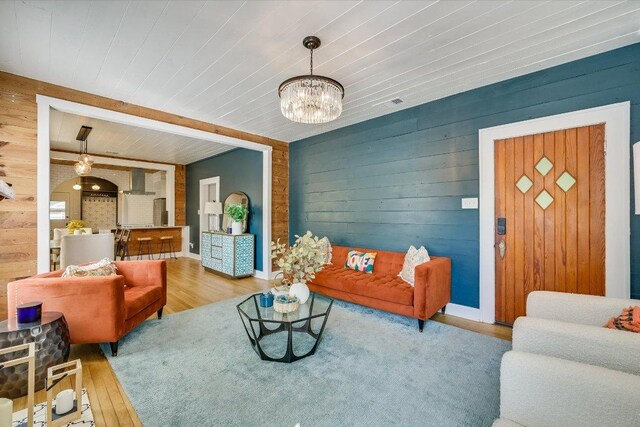 510 E 38th St, Austin, TX 78705 - living room featuring wood walls, arched walkways, wood finished floors, wood ceiling, and a chandelier