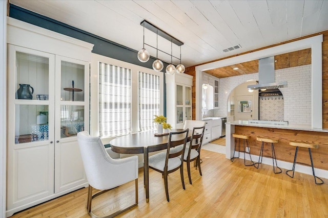 510 E 38th St, Austin, TX 78705 - dining space with wooden ceiling, light wood-style flooring, arched walkways, and brick wall