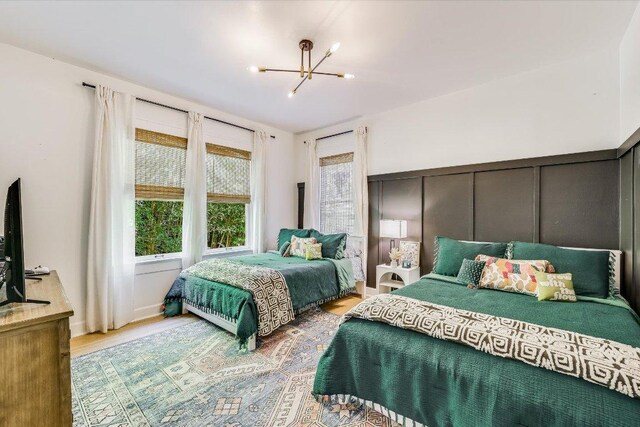510 E 38th St, Austin, TX 78705 - bedroom with a chandelier, wood finished floors, and a decorative wall