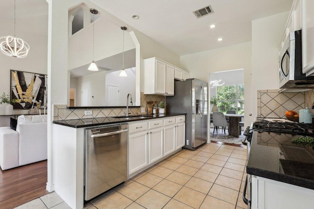2807 Glenwood Trl, Cedar Park, TX 78613 - kitchen featuring stainless steel appliances, dark countertops, white cabinetry, tasteful backsplash, and light tile patterned floors