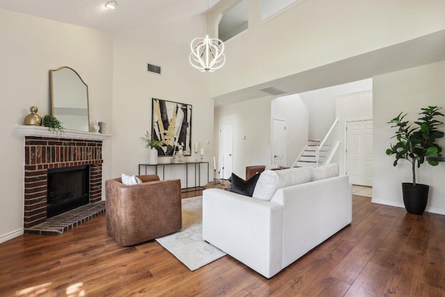 2807 Glenwood Trl, Cedar Park, TX 78613 - living area featuring a chandelier, wood-type flooring, stairway, a brick fireplace, and high vaulted ceiling