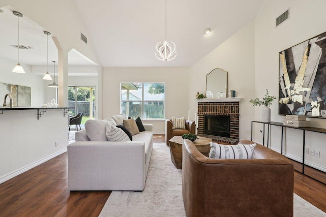 2807 Glenwood Trl, Cedar Park, TX 78613 - living room with wood finished floors, a chandelier, high vaulted ceiling, and a brick fireplace