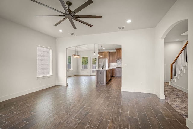 182 W Torrey St, New Braunfels, TX 78130 - unfurnished living room featuring ceiling fan, dark wood finished floors, arched walkways, and recessed lighting