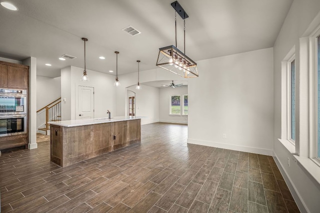 182 W Torrey St, New Braunfels, TX 78130 - kitchen with ceiling fan, stainless steel double oven, dark wood-style flooring, brown cabinets, and recessed lighting
