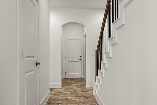 182 W Torrey St, New Braunfels, TX 78130 - hall featuring brick patterned floors, arched walkways, and stairway