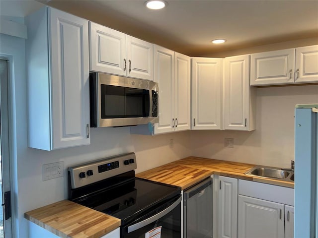 1015 E Yager Ln Unit 77, Austin, TX 78753 - kitchen with stainless steel appliances, wooden counters, white cabinets, and recessed lighting