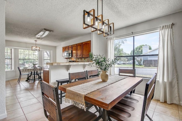 17516 Klamath Falls Dr, Round Rock, TX 78681 - dining area featuring a chandelier, a textured ceiling, and light tile patterned flooring