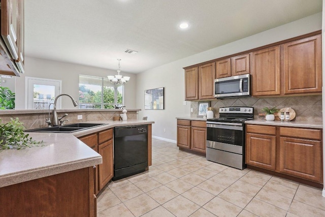 212 Boone Valley Dr, Round Rock, TX 78664 - kitchen with appliances with stainless steel finishes, brown cabinets, backsplash, light tile patterned floors, and light countertops