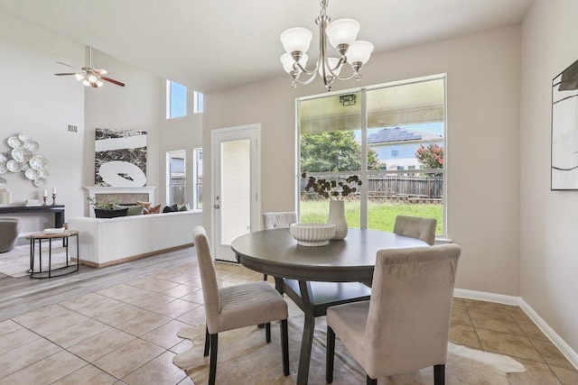 212 Boone Valley Dr, Round Rock, TX 78664 - dining area with light tile patterned flooring, a chandelier, a ceiling fan, and a fireplace