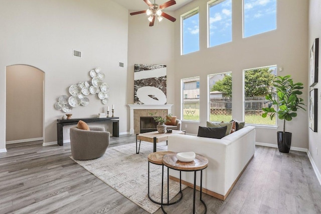 212 Boone Valley Dr, Round Rock, TX 78664 - living area featuring a high ceiling, a fireplace, healthy amount of natural light, wood finished floors, and a ceiling fan