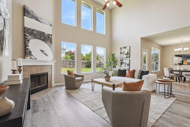 212 Boone Valley Dr, Round Rock, TX 78664 - living room with a towering ceiling, a fireplace, light wood finished floors, a chandelier, and ceiling fan