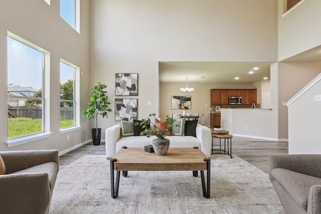 212 Boone Valley Dr, Round Rock, TX 78664 - living room featuring a high ceiling, light wood-type flooring, and a chandelier