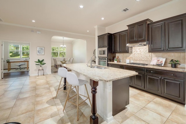 1200 Falling Hills Dr, Georgetown, TX 78628 - kitchen with arched walkways, tasteful backsplash, stainless steel appliances, a breakfast bar area, and recessed lighting