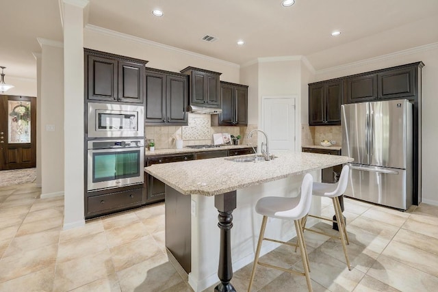 1200 Falling Hills Dr, Georgetown, TX 78628 - kitchen with appliances with stainless steel finishes, a breakfast bar, light stone countertops, crown molding, and decorative backsplash
