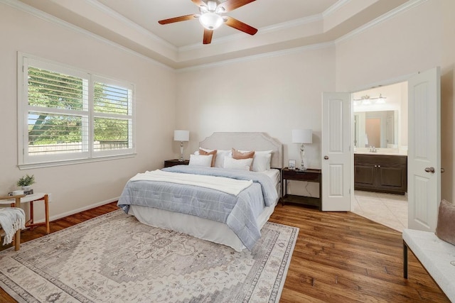 1200 Falling Hills Dr, Georgetown, TX 78628 - bedroom with light wood-style flooring, crown molding, a raised ceiling, ensuite bathroom, and a ceiling fan