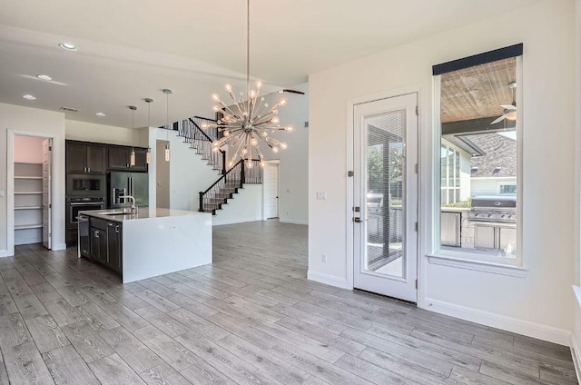 520 Germander Rd, Leander, TX 78641 - kitchen with stainless steel appliances, light wood-type flooring, open floor plan, a center island with sink, and recessed lighting
