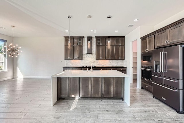 520 Germander Rd, Leander, TX 78641 - kitchen featuring appliances with stainless steel finishes, wall chimney range hood, wood tiled floors, dark brown cabinetry, and backsplash
