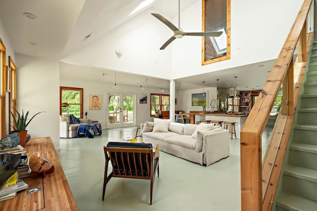 5204 Cueva Dr, Austin, TX 78738 - living room featuring a skylight, ceiling fan, high vaulted ceiling, stairway, and french doors